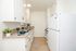 Sleek modern kitchen with elegant white cabinetry, stylish granite countertops, and a cozy layout featuring charming decor and natural light.