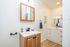 Elegant bathroom with warm wood cabinetry, sleek modern fixtures, and ample storage space.