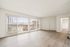 Bright and airy living room with large windows, wooden flooring, and modern design.
