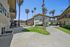 Charming apartment complex featuring lush green lawns, palm trees, and modern architecture, perfect for comfortable living.