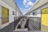 Charming apartment complex with vibrant yellow doors and a serene open-air corridor, perfect for modern urban living.