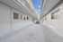 Charming apartment complex featuring a clean and inviting walkway with a central planter and stylish windows, offering a modern urban living experience.