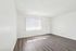 Bright and airy room with modern wood flooring, a large window with vertical blinds, and minimalist white walls, perfect for customizing your dream space.