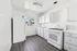Bright and airy kitchen with modern white cabinetry, sleek flooring, and ample natural light from a picturesque window.