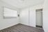 Bright and airy room with sleek flooring, large window with vertical blinds, and a spacious closet, perfect for a modern living space.