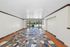 Vibrant living space featuring colorful mosaic tile flooring, large glass doors opening to a serene garden view, and abundant natural light.