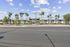 Charming apartment complex with modern architecture, surrounded by palm trees and bathed in beautiful sunlight.