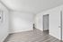 Bright and modern room with sleek laminate flooring and white walls, offering a clean and spacious feel.