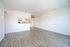 Contemporary open-plan living space with sleek hardwood floors and a modern kitchen nook, ideal for stylish entertaining.