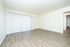 Bright and airy living room with sleek wood flooring and expansive sliding glass doors leading to a private balcony.