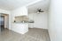 Bright and modern open-concept kitchen with sleek countertops, light wood flooring, and contemporary ceiling fan, perfect for stylish living.