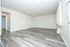Spacious and modern living room with sleek wooden flooring and bright white walls, ready to be personalized.
