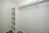 Spacious walk-in closet with ample shelving and hanging space in a modern apartment.
