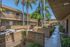 Charming apartment courtyard with lush landscaping, palm trees, and modern architecture.