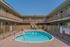 Inviting apartment courtyard featuring a sparkling swimming pool and well-maintained balconies, perfect for a relaxing community atmosphere.