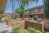 Charming outdoor courtyard with lush greenery and palm trees in a modern apartment complex.