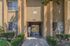 Inviting apartment entrance with charming landscaping and secure gated entry, offering a welcoming feel and peaceful ambiance.