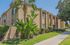 Modern apartment complex with lush landscaping, featuring vibrant greenery and a sleek architectural design.
