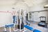 Modern fitness center with state-of-the-art exercise equipment, featuring a treadmill and multi-station gym machine in a bright, airy space.