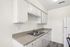 Modern kitchen with sleek white cabinets, spacious countertops, and a double sink.