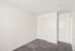 Bright and spacious bedroom with plush carpeting and sleek white closet doors, perfect for modern living.
