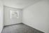 Bright and cozy bedroom with soft carpeting and a large window inviting natural light.