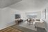 Bright and modern living room with cozy seating, elegant decor, and a panoramic view from large windows.
