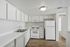 Bright and modern kitchen with sleek white cabinetry, spacious countertops, and hardwood flooring, creating an inviting space for culinary creativity.