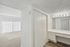 Bright and inviting apartment space featuring a spacious walk-in closet, modern vanity area with ample lighting, and large windows with vertical blinds providing natural sunlight.
