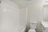 Bright, modern bathroom with a sleek bathtub, pristine white walls, and a contemporary vanity, offering a serene spa-like ambiance.