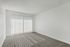 Bright and spacious room with large windows and plush carpeting, perfect for relaxation and comfort.
