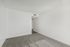 Bright, open corner room with soft carpeting and neutral walls, perfect for personalization and cozy living.