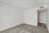 Bright and airy room with a neutral palette, plush carpet, and sleek doorway, perfect for a cozy retreat.