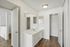 Bright and modern bathroom with sleek white cabinets and spacious vanity area, featuring elegant lighting and stylish hardwood floors.