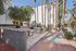 Charming outdoor area with picnic tables, lush greenery, and majestic palm trees, perfect for relaxation and community gatherings.