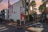 Charming apartment complex, The Villas, with elegant landscaping and a modern gated entrance, set against a beautiful sunset sky.