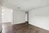 Spacious and bright living area with elegant hardwood floors and fresh white walls, perfect for stylish modern living.