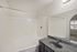 Modern bathroom with sleek granite countertop, large mirror, and pristine bathtub, inviting relaxation and style.