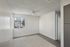 Bright and airy living space with a modern ceiling fan, large window offering natural light, and sleek flooring in a cozy apartment.