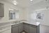 Bright, modern kitchen with sleek countertops, dual sink, and ample natural light from large windows.