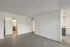 Elegant apartment interior featuring a spacious room with modern hardwood flooring, an arched doorway leading to a well-lit bathroom, and a sleek counter space.