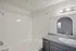 Bright and modern bathroom featuring a sleek vanity, spacious bathtub, and elegant lighting.