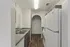 Modern galley kitchen with sleek countertops, stainless steel double sink, and elegant archway entrance.