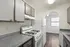 Charming kitchen featuring modern gray cabinetry, sleek countertops, and a white gas stove enhancing the bright, open space.
