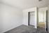 Bright bedroom with plush carpet, built-in closet, and modern design in a fresh apartment.