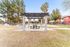 Inviting outdoor space featuring a charming pergola with picnic tables, surrounded by lush greenery and towering palm trees in a tranquil community setting.