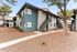 Charming desert-style apartment complex with modern two-toned facade and outdoor staircase surrounded by landscaped grounds.