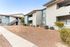 Charming apartment exterior with modern two-story design, stucco walls, and a peaceful, landscaped courtyard.
