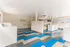 Bright and spacious laundry room featuring modern white machines and bold geometric flooring design.