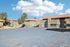 Charming apartment complex with basketball court, perfect for outdoor fun under a clear blue sky.